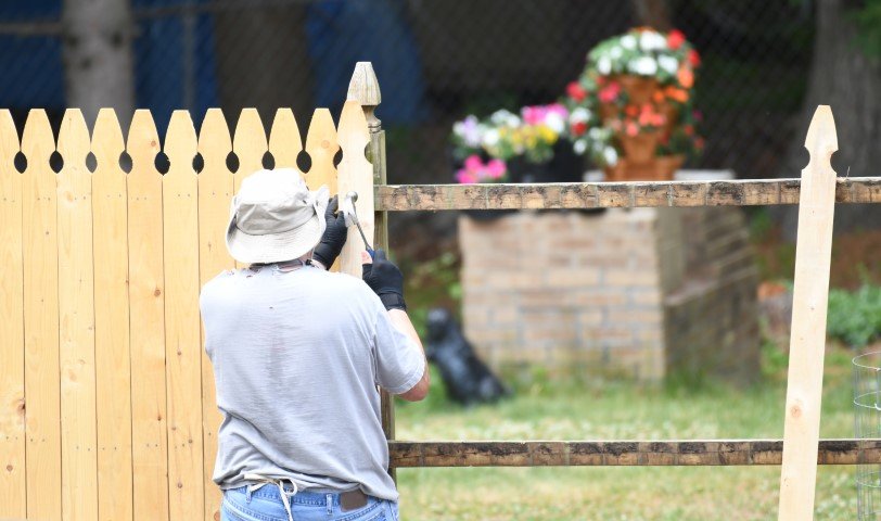 manual worker installing the wood fence in the yard